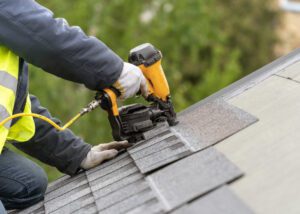 Roofer installing shingles