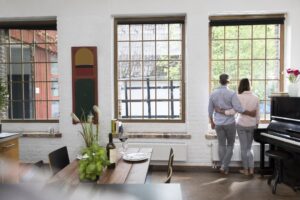 couple looking out the window with colonial grids