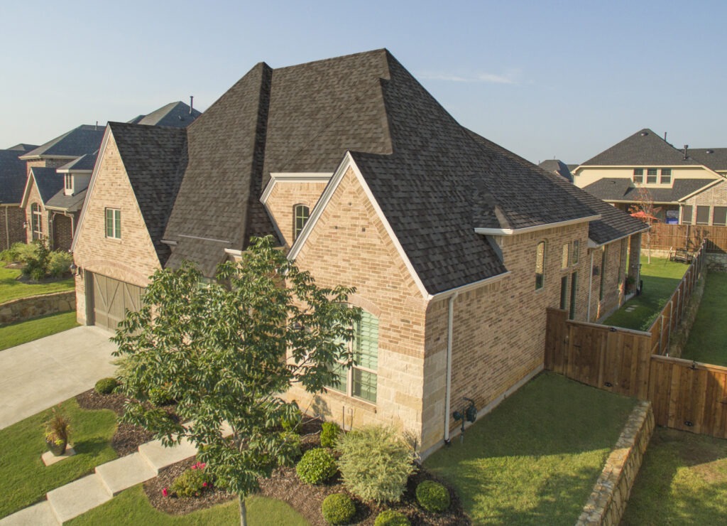 Aerial view of suburban brick house with garden.