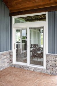 Glass sliding door on porch with stone wall