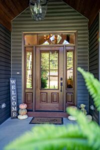 Cozy porch with pumpkins and welcome sign.