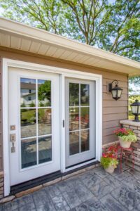 White patio doors with outdoor landscaping.