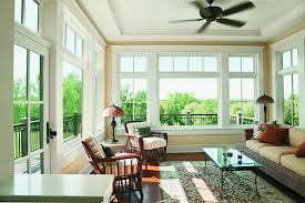 Bright sunroom with large windows and cozy furniture.