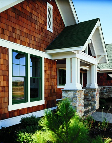 Modern house with wooden siding and stone accents.