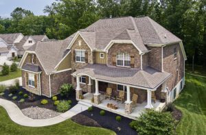 house with weathered wood shingles, brown brick, white trims 