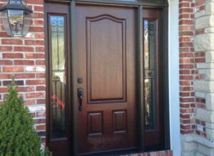 Elegant wooden front door with side glass panels.