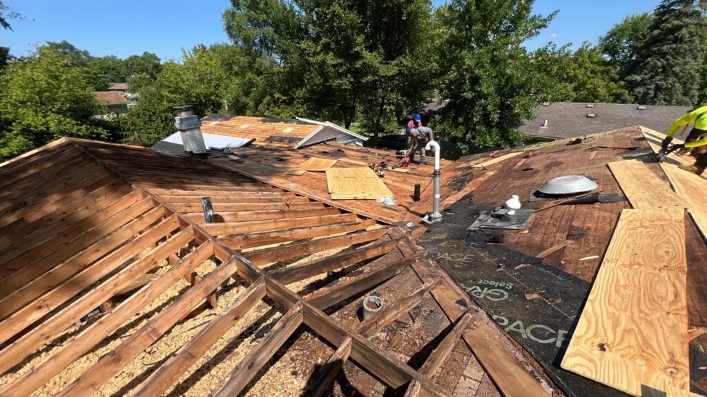Workers repairing a wooden roof in progress