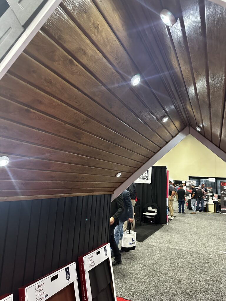 Trade show exhibit with wood panel ceiling and lights.