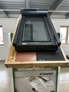Fakro skylight window display with roofing materials.