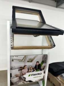 Fakro roof window display with family illustration.