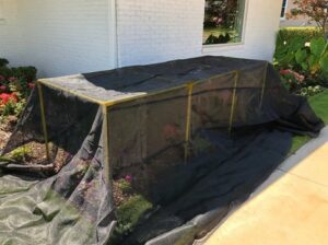 Garden bed covered with black protective mesh