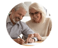 Smiling senior couple signing documents together at table