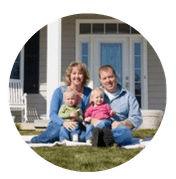 Family of four sitting on front lawn