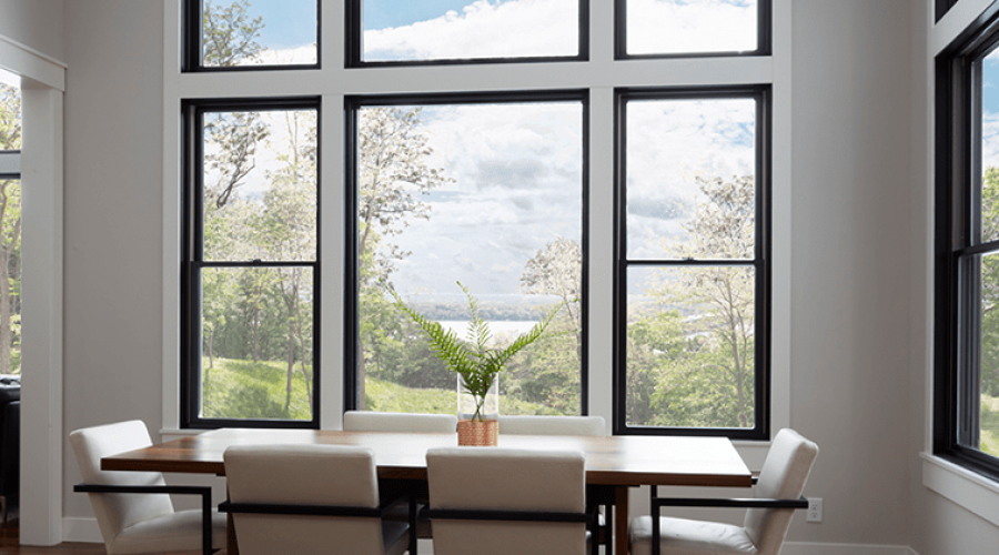 Modern dining room with large windows and scenic view.