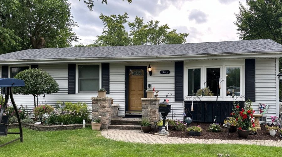Charming gray siding house with garden and swing.