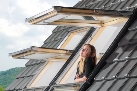 Woman looking out from rooftop windows