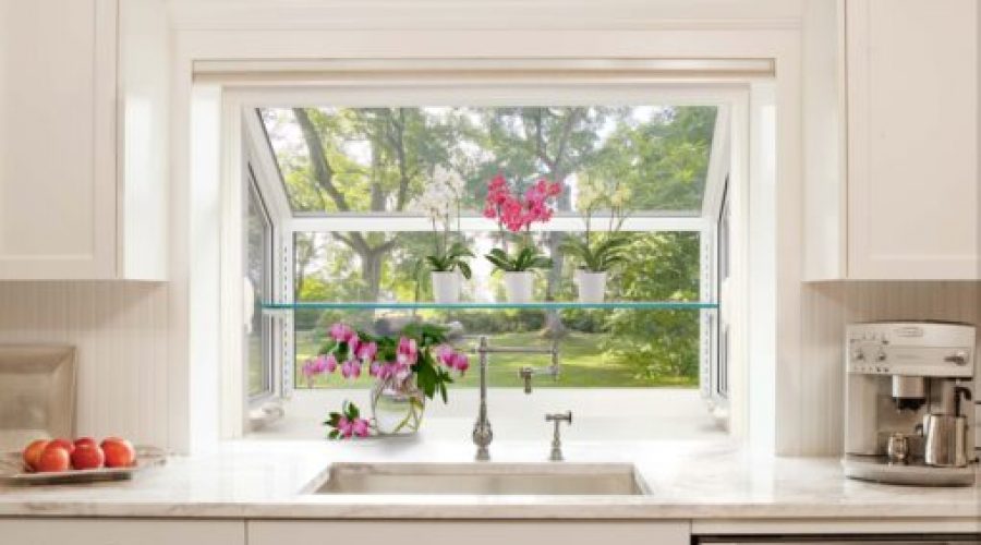 Garden-Window Kitchen sink view with plants and coffee maker.