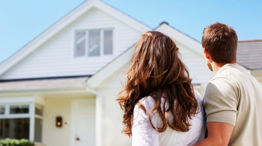 Couple admiring white suburban house.