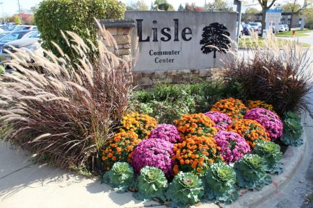 Colorful flowers at Lisle Commuter Center sign.