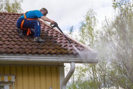 man-cleaning-roof-with-water-pressure