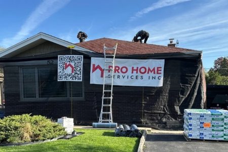 Home renovation with workers on roof and equipment.